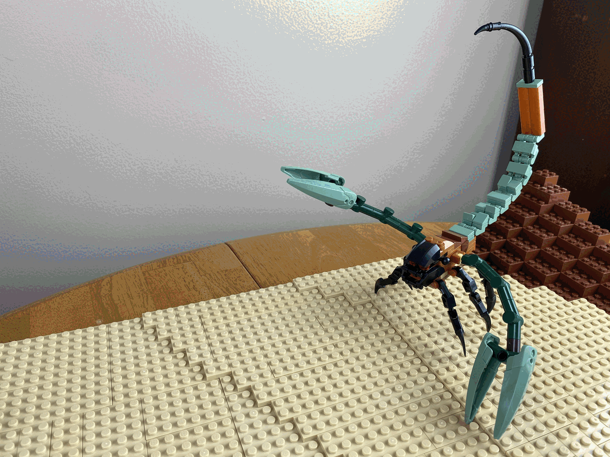 An animated GIF showing a LEGO scorpion-like creature killing a LEGO monkey (representing Bigglesworth).