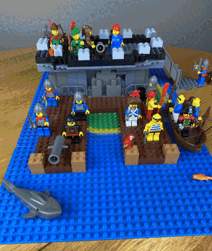 An animated LEGO scene featuring numerous figures on a blue baseplate representing water. The scene shows the type of work that Annette Dazzlecraft used to do a defense contractor. Inspecting cannons and siege weapons.